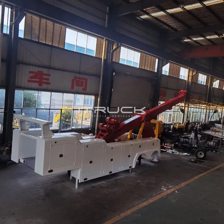 Full-length white wrecker body with red boom in the workshop